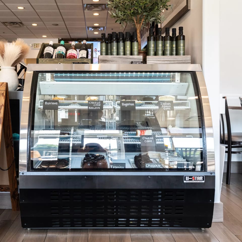 Dessert display case at Anthony's Restaurant, featuring baklava, cheesecake, tiramisu, and chocolate cake.